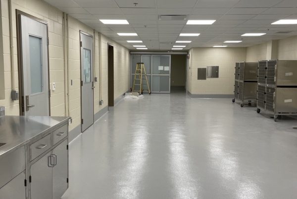 small animal anesthesia recovery room with holding kennels, grey floors, and stainless steal counters.