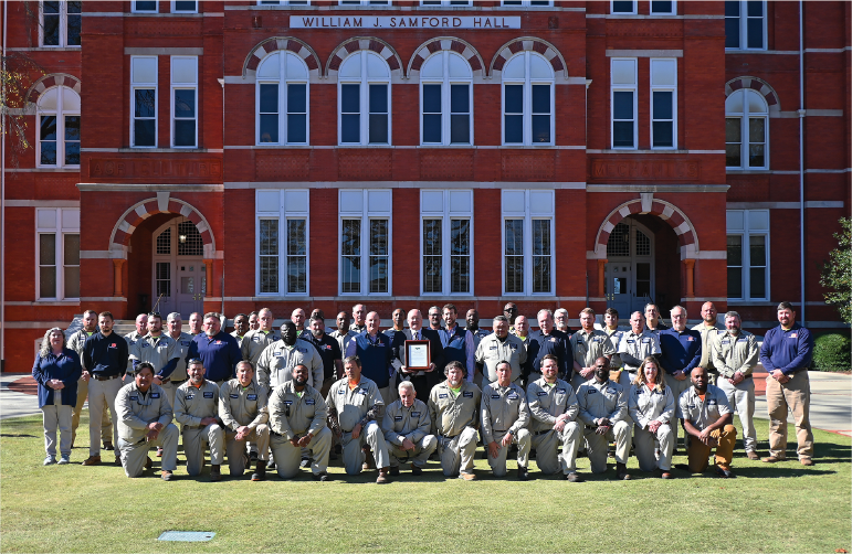 Landscape Services team posing from of Samford Hall with award.
