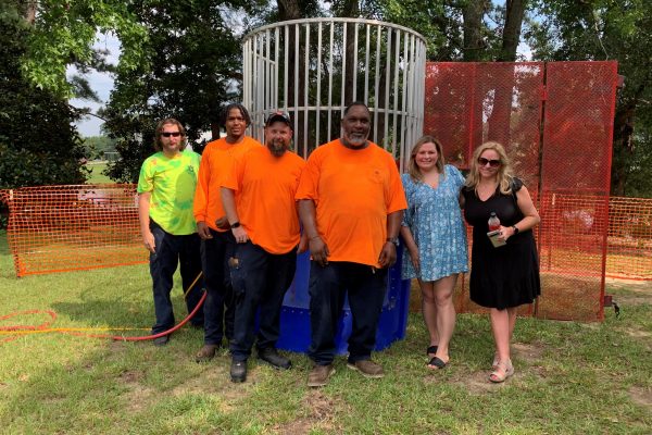 From left: Phillip Thompson, Elijah Jenkins, Layne Black and Oshia Cason, all of Construction, and Mary Stuart and Laurie Hanson of PD&C set up the dunking booth.