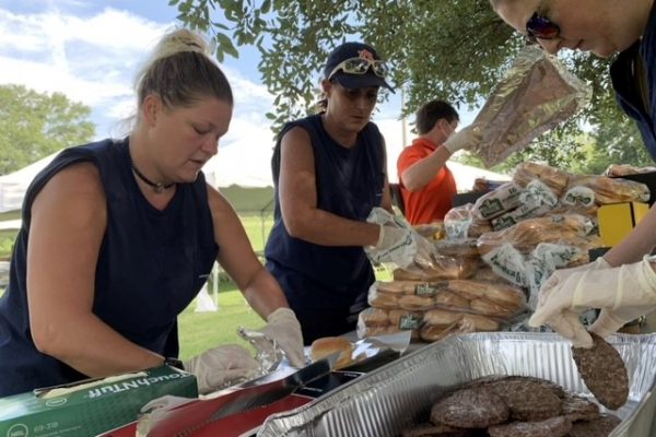 Scooter Herrmann (IT), Tracy Dixon (Maintenance), Jesse Teel (WRRD) and Wendy Peacock (PD&C) wrap hamburgers that are fresh off the grill.