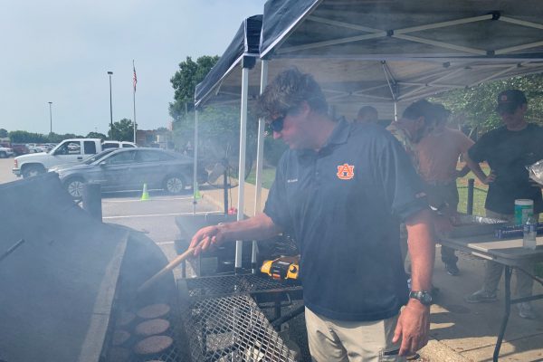 Tyler Hand of PD&C grills the day’s first round of burgers.