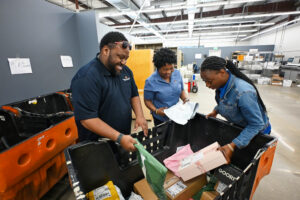 Anthony Driver, Lakendra Peavey and Shaniece Gray sort packages for campus delivery.