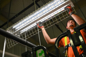Cullen Kennedy installs light fixture.